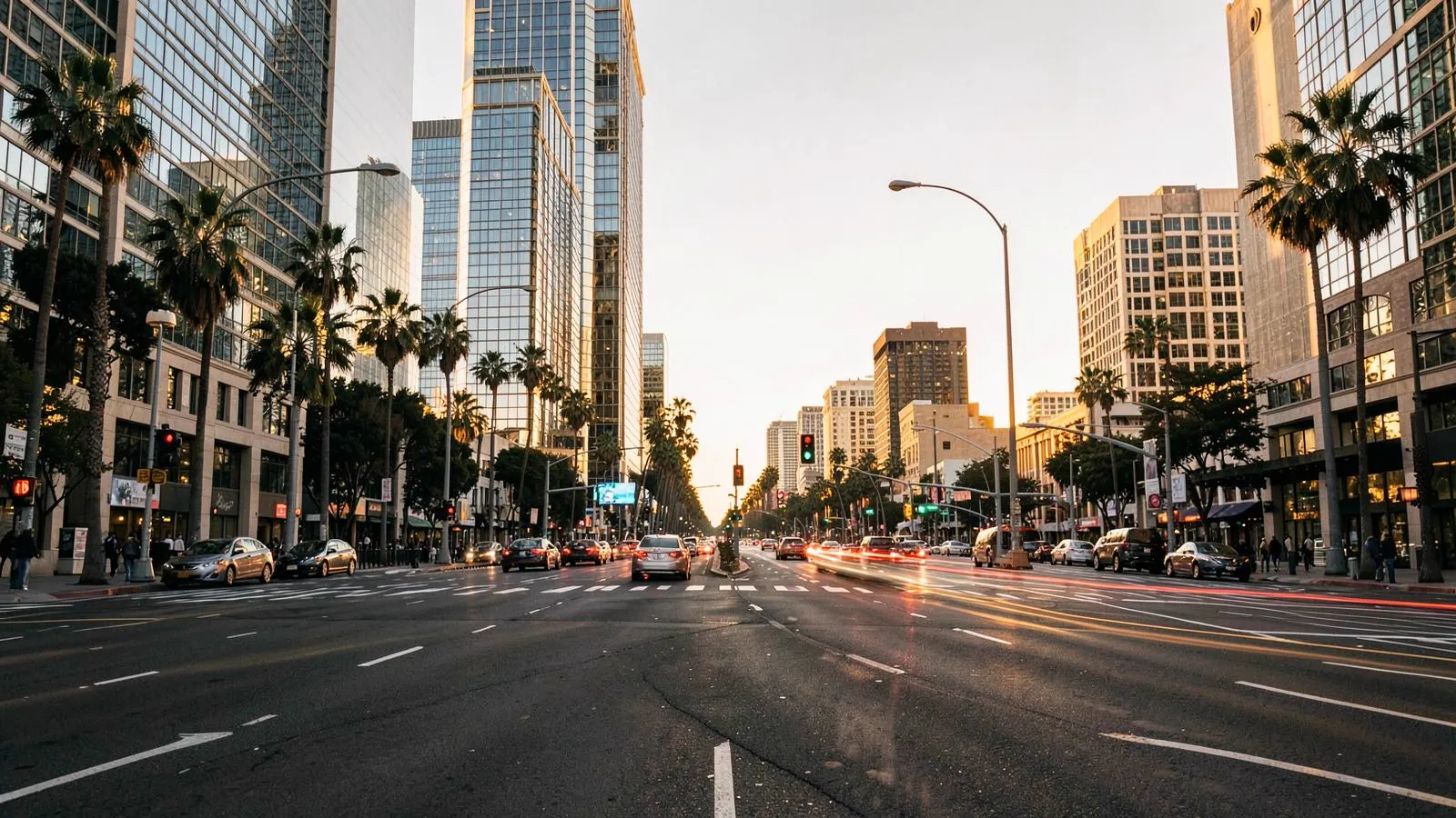Wide multi-lane boulevard intersection in Century City, Los Angeles at golden hour